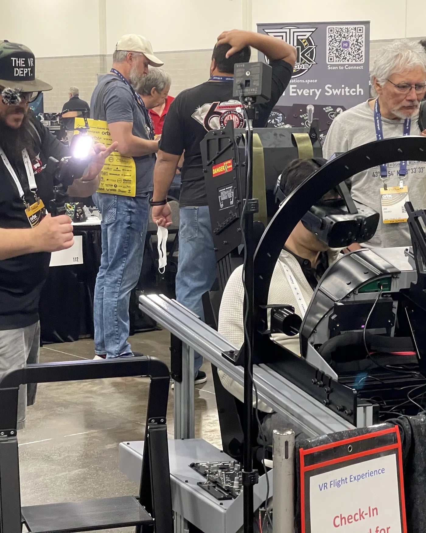 FlightSimExpo attendee examining the Dogfight Dynamics cockpit